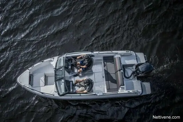 Two men in a small motorboat navigate across dark water, engaged in steering and using navigational equipment.